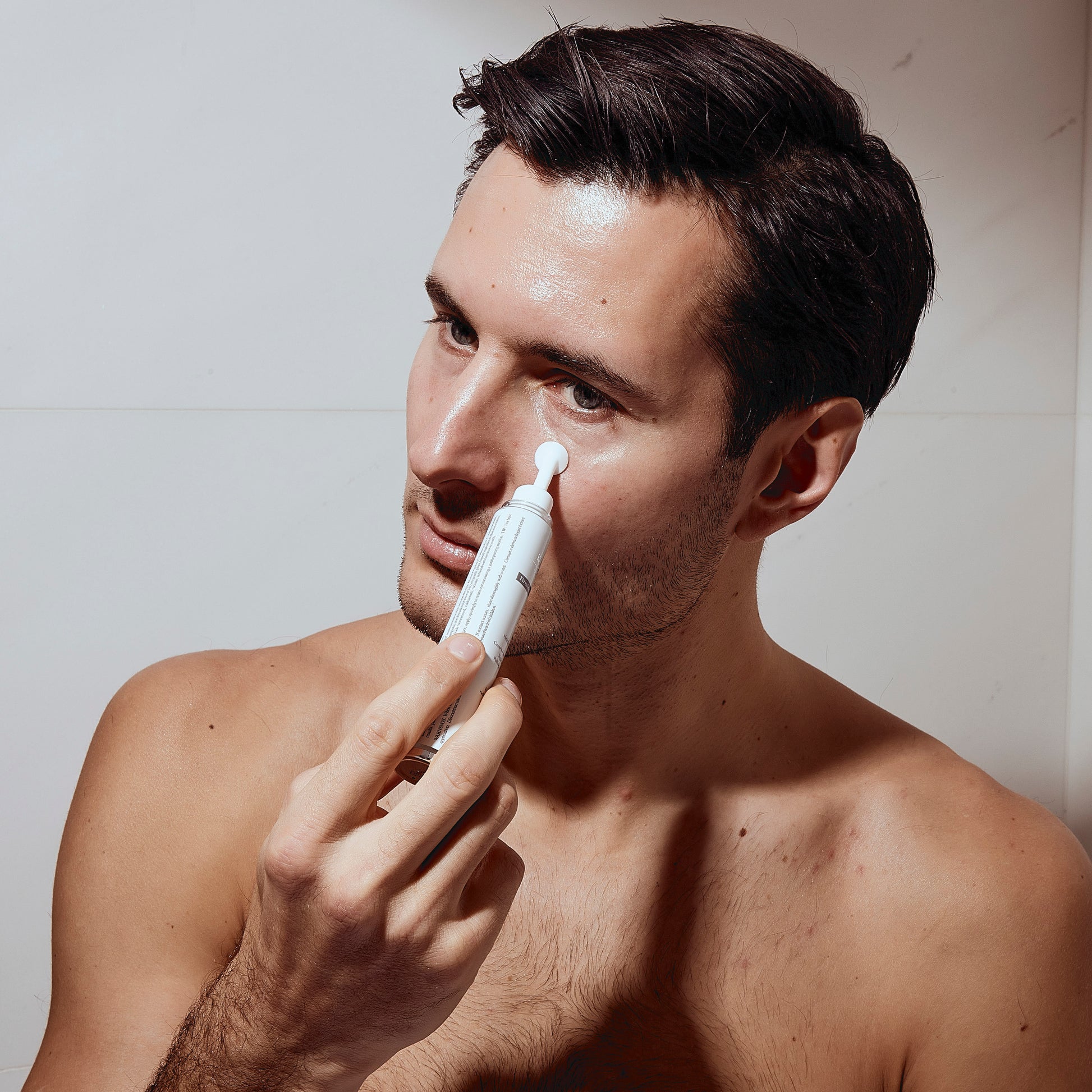Man applying Kleem Organics Firming Eye Cream to under-eye area: brightening and depuffing skincare routine